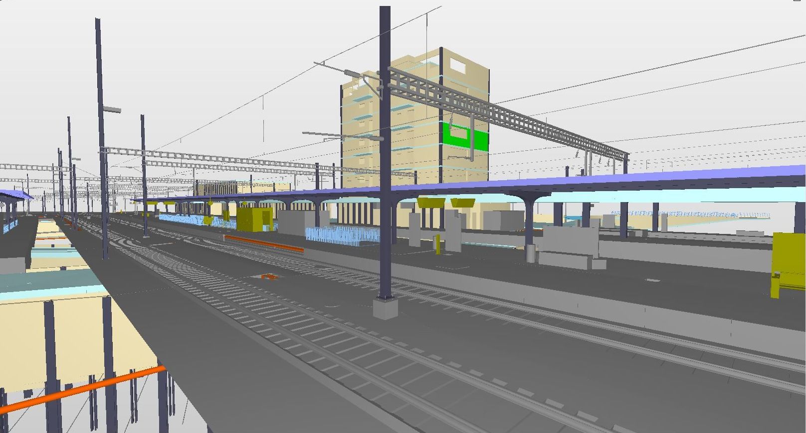 Eine digitale Darstellung eines Bahnhofs mit mehreren Gleisen und Bahnsteigen. Oberleitungen sind sichtbar. Es sind verschiedene Strukturen vorhanden, darunter ein großes Gebäude und kleinere Bahnsteigüberdachungen. Die Szene hat keine detaillierten Texturen und wirkt in einem minimalistischen Stil.